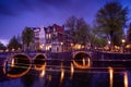 Amsterdam by night with floating boats on the river canal , evening time , travelling to Netherlands