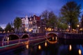 Amsterdam by night with floating boats on the river canal , evening time , travelling to Netherlands