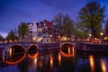 Amsterdam by night with floating boats on the river canal , evening time , travelling to Netherlands