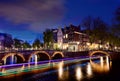 Amsterdam by night with floating boats on the river canal , evening time , travelling to Netherlands