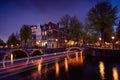 Amsterdam by night with floating boats on the river canal , evening time , travelling to Netherlands