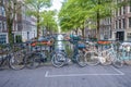 Amsterdam. Parked bikes on a bridge over canal and moored boat and houseboat on water. Netherlands Royalty Free Stock Photo