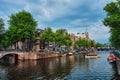 Amsterdam view - canal with boad, bridge and old houses Royalty Free Stock Photo