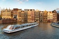 Amsterdam waterfront houses and canal tour boats at sunset, North Holland, Netherlands, transport, traveling Royalty Free Stock Photo