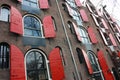 Amsterdam, windows in row with opened red shutters, shooting from below in historical building