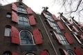 Amsterdam, windows in row with opened red shutters, shooting from below in historical building