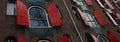 Amsterdam, windows in row with opened red shutters, shooting from below in historical building