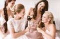 Amused bride and bridesmaids having hen party at home