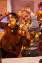 Amused couple caughting in christmas tree light during christmastime