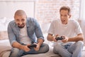 Amused friends playing with game console on the bed