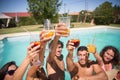 Amused friends resting at poolside in summer