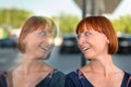 Amused joyful woman looking at her own reflection in a window