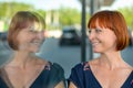 Amused joyful woman looking at her own reflection in a window