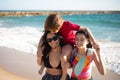 Amused sisters and brother at beach