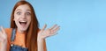 Amused speechless surprised astonished redhead girl hear exciting positive news smiling gladly wide eyes thrilled raised Royalty Free Stock Photo