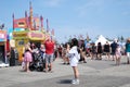 amusement park adults and children stroll against backdrop of swing. people have fun on summer autumn day. teenagers buy