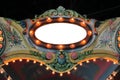 Amusement park carousel floral cresting with lights and mirror Royalty Free Stock Photo