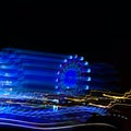 Amusement Park at night - Ferris wheel neon glow in motion with place under text. glowing vertical lines, neon lights, abstract