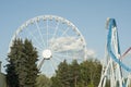 Amusement park. People having fun. Ferries wheel and roller coaster. Royalty Free Stock Photo