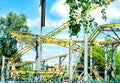 Amusement Park roller coaster ride, against the background of trees and blue sky in bright sunlight, no one Royalty Free Stock Photo