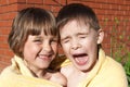 An amusing girl and boy are wrapped in a towel