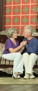 Amusing happy smiling old couple sitting on sofa