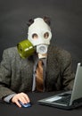 Amusing person in gas mask works with computer Royalty Free Stock Photo