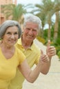 Amusing smiling senior couple with thumbs up