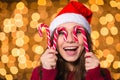 Amusing young female making funny face using christmas lollypops Royalty Free Stock Photo