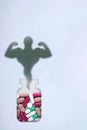 Anabolic, sports dope in bank and the image of a bodybuilder in the form of a shadow. Medical concept of abuse of doping