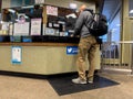 Anacortes, WA USA - circa November 2022: Wide view of a man purchasing a ferry ticket inside a Washington State Ferry terminal