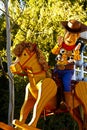 Woody from Toy Story is riding on a rocking horse on a float in Disneyland