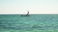 Anakao, Madagascar - May 04, 2019: Lone piroga traditional small fishing boat with single sail aboard three fisherman sailing