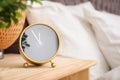 Analog alarm clock on table in bedroom