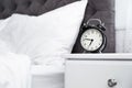 Analog alarm clock on table in bedroom Royalty Free Stock Photo