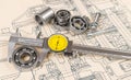 Analog caliper detail. Accurate measuring of a ball bearing diameter on technical drawing background Royalty Free Stock Photo