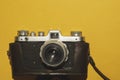 Analog camera on yellow background. copy space