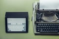 Analog and digital typewriters lie on the green surface. Continuity of generations, technology development concept Royalty Free Stock Photo