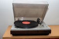 Analog retro vintage stereo turntable on a wooden table. An old-fashioned plastic turntable playing a music track Royalty Free Stock Photo