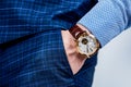 Analog wrist watch worn on male arm in trousers pocket, wristwatch Royalty Free Stock Photo