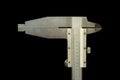 Analogue vernier calliper made of stainless steel for precise measurements, isolated on black background