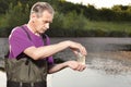 Analyst in chest waders bootfoot closing bottle with collected sample