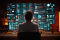 Analyst monitoring multiple data dashboards on high-tech screens in a cybersecurity or data analysis environment Royalty Free Stock Photo
