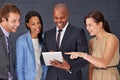 Analyzing the quarterly results. a group of businesspeople working over a digital tablet. Royalty Free Stock Photo