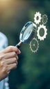 Analyzing System Processes: Magnifying Glass Examining Gears Representing Operation, Integration, Mechanism, and Functionality in Royalty Free Stock Photo