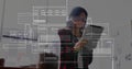 Analyzing woman interacting with floating data interfaces in office, with tablet and laptop Royalty Free Stock Photo