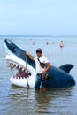 Anapa, Russia - 5 August 2016: illegal entrepreneur offers on beach in Anapa to be photographed with toy shark head for memorable