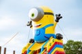 Huge inflatable figure one-eyed yellow minion. Inflatable children`s attraction trampoline in a publi