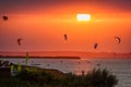 Kitesurfers ride kites on Bugaz lake at Anapa resort at summer sunset