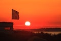 Scenic sunset landscape at Black Sea Blaga Beach resort with waving flag silhouette. Summer seaside scenery with setting sun. Camp